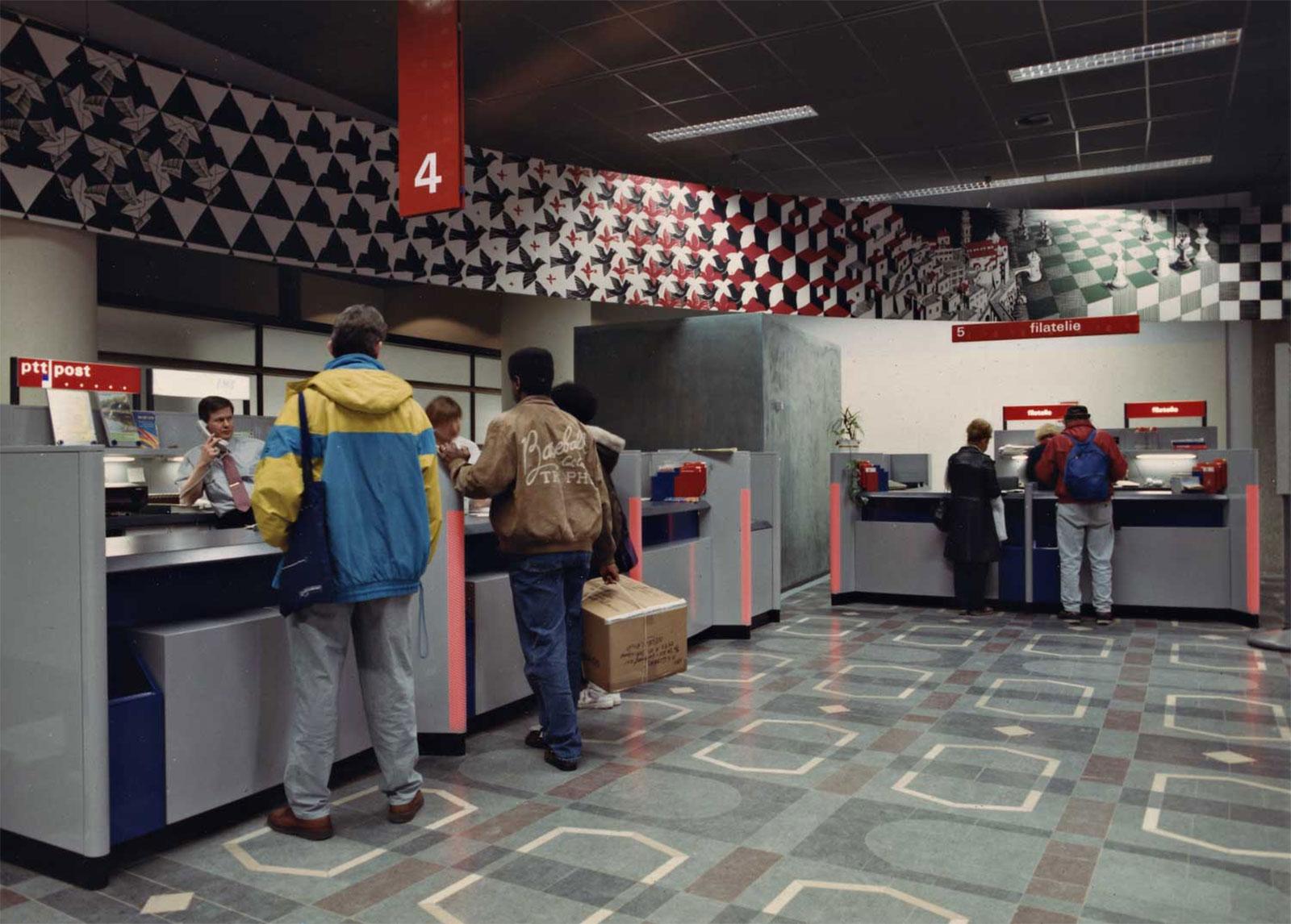 <p>The central public area with the service counters, above which runs Escher's Metamorphosis. Collection Beeld en Geluid Den Haag | Photographer unknown | 1990s</p>